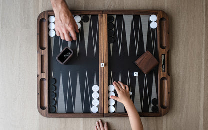A man and a child playing Fire Road Skyline Backgammon Set.