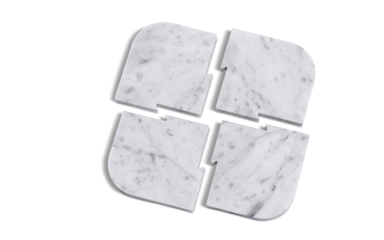 A Fire Road Marble Serving Set of four marble coasters on a white surface.