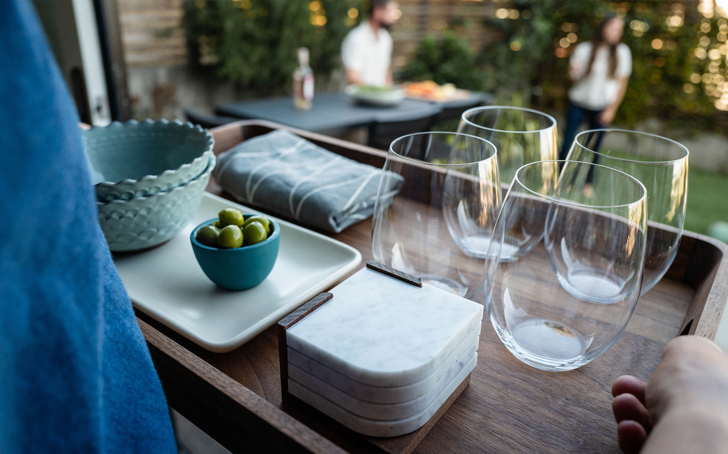 wood tray with plates and cups at backyard party