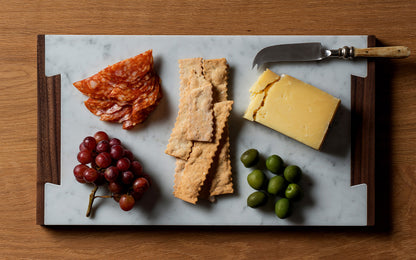 marble cheese board with olives and grapes