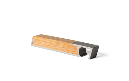 A Fire Road wooden block with a metal handle for a Profile Bottle Opener on a white surface.