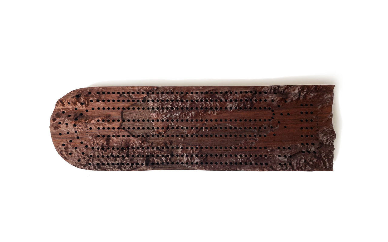 A Fire Road Terrain cribbage board with holes in it.
