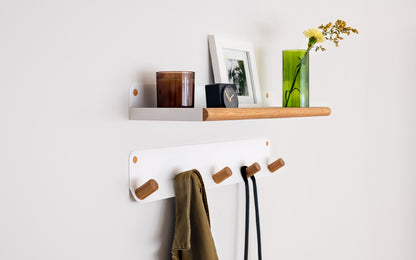 Fire Road's Plane 5 Wall Hook, a wall-mounted wooden shelf with a vase and coat hooks.