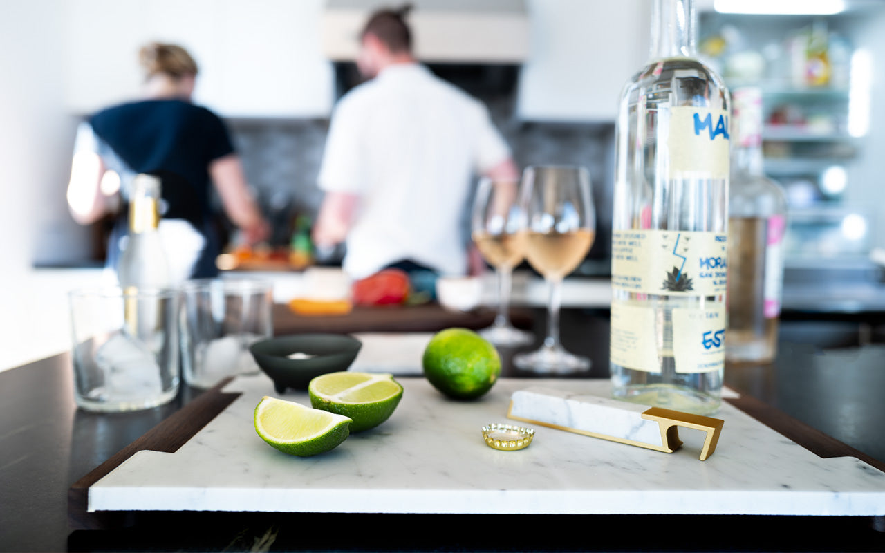 marble serving board with bottle opener and limes