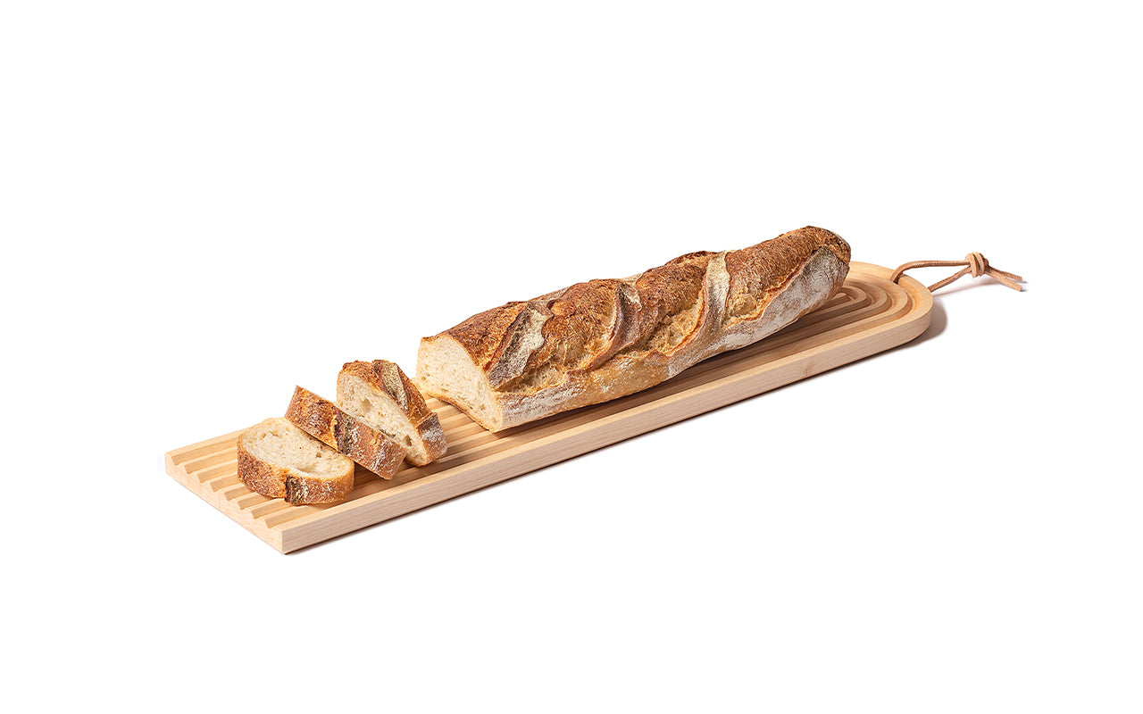 maple wood board with grooves and baguette on top